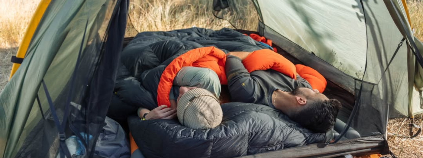 Two people lying inside a tent in a natural outdoor setting I zenbivy.eu