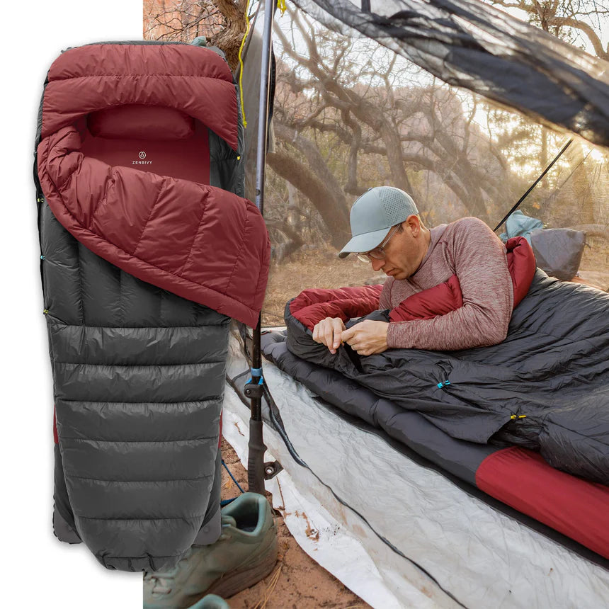 Person using a camping sleeping bag outdoors with a tent in the background  | zenbivy.eu